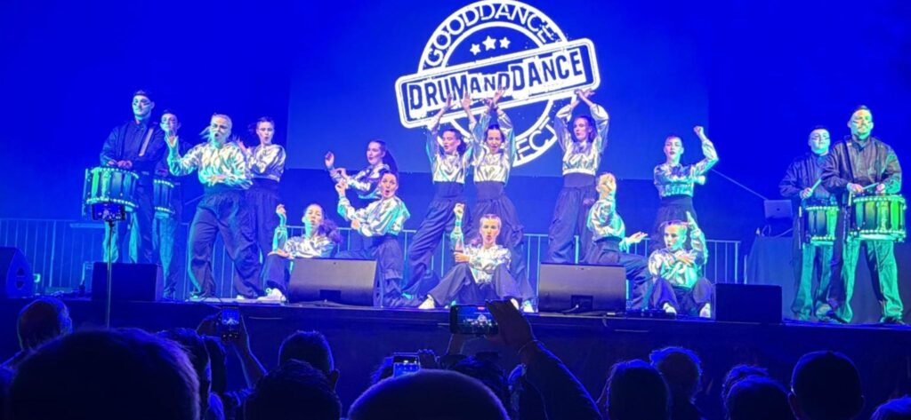 Tänzerinnen der Tanzschule „Good Dance“ und Trommler des Spielmannszugs Bernburg auf einer Bühne beim Blasmusikfest.