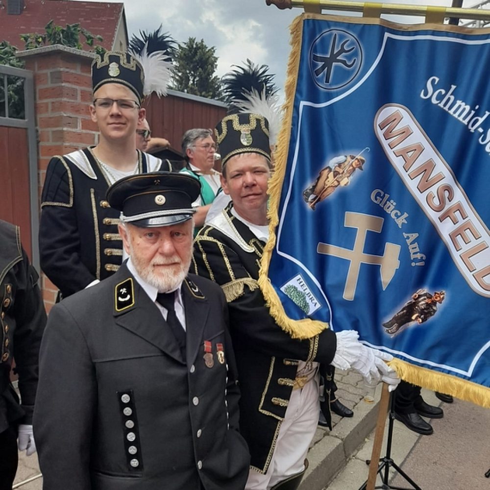 Traditionell gekleidete Männer mit Uniform und Bergmannsbanner ‚Mansfeld – Glück Auf‘ beim Umzug.