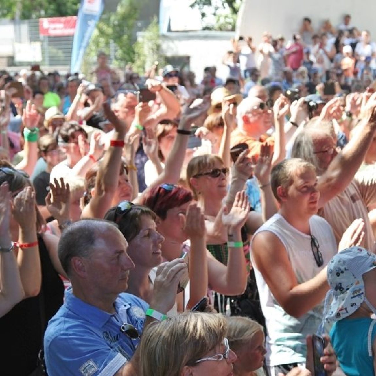 Menschenmenge beim Blasmusikfest, viele Besucher klatschen und jubeln.